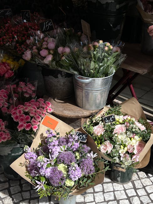 A display of fresh floral arrangements outside a flower shop on Eltham High Street, featuring a variety of flowers in different colours and styles. In the foreground, a bouquet with purple and lavende